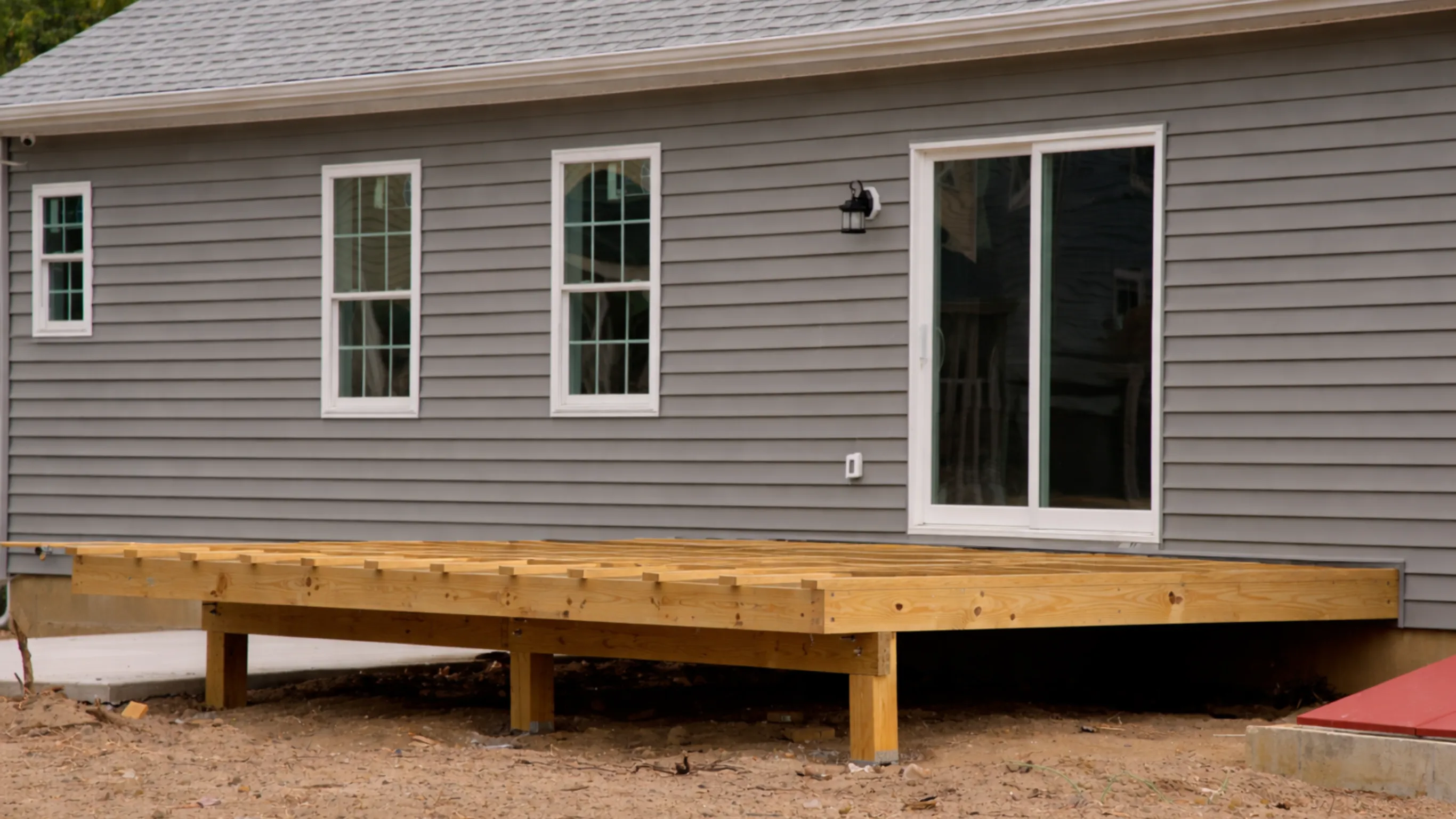 Residential deck framing project in Dallas showing exposed wood platform and structural support posts before finishing.